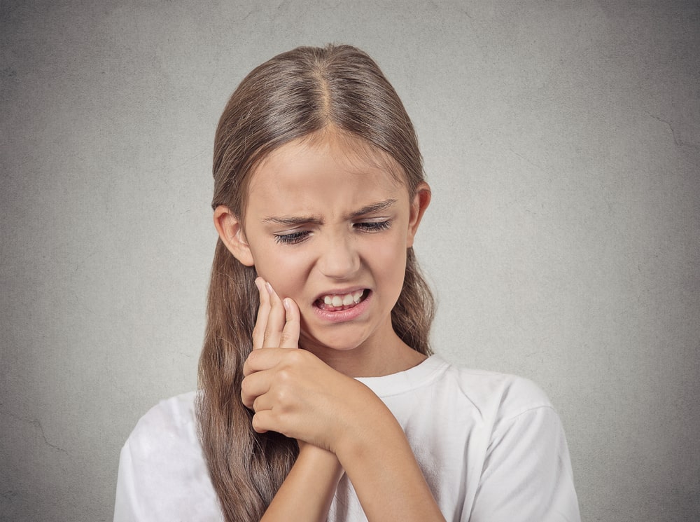young teenager girl with sensitive tooth ache